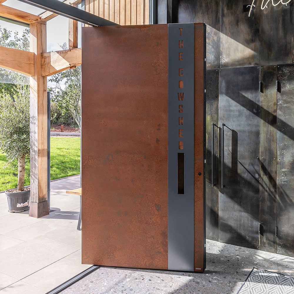 Liquid metal rust finish pivot door at the Cow Shed